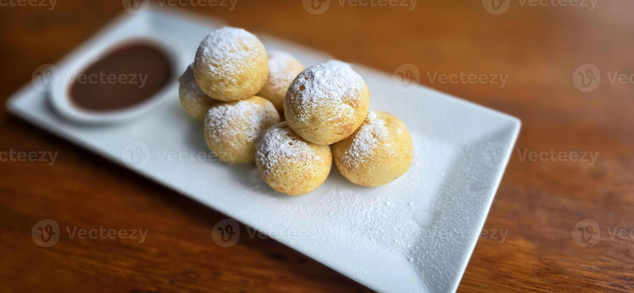 fait maison néerlandais poffertjes mini Crêpes avec glaçage en poudre sucre et Chocolat plombages avec Additionnel Chocolat sauce photo