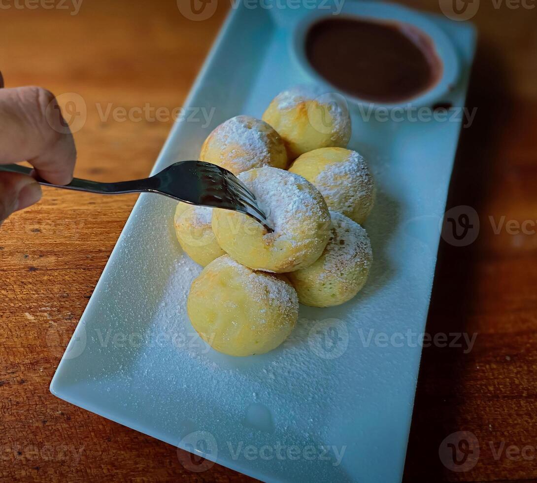 fait maison néerlandais poffertjes mini Crêpes avec glaçage en poudre sucre et Chocolat plombages avec Additionnel Chocolat sauce photo