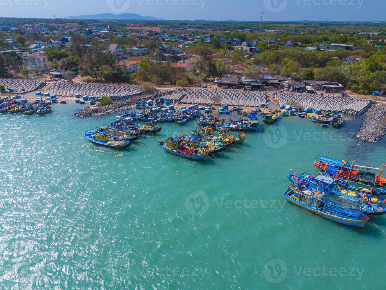 aérien vue de loc un pêche village, vung tau ville. une pêche Port avec tsunami protection béton blocs. paysage urbain et traditionnel bateaux dans le mer. photo
