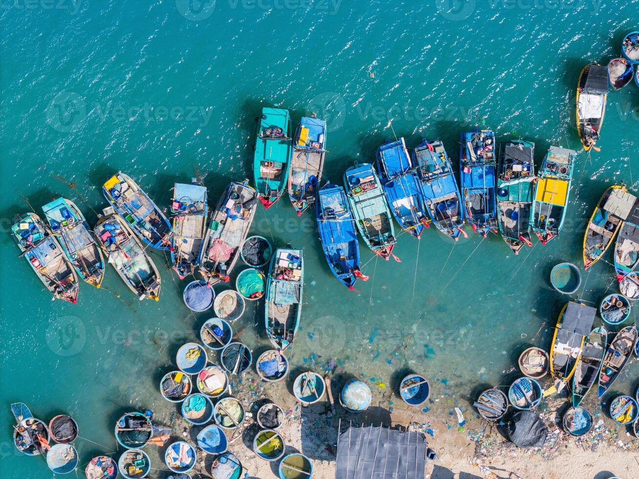 aérien vue de loc un pêche village, vung tau ville. une pêche Port avec tsunami protection béton blocs. paysage urbain et traditionnel bateaux dans le mer. photo