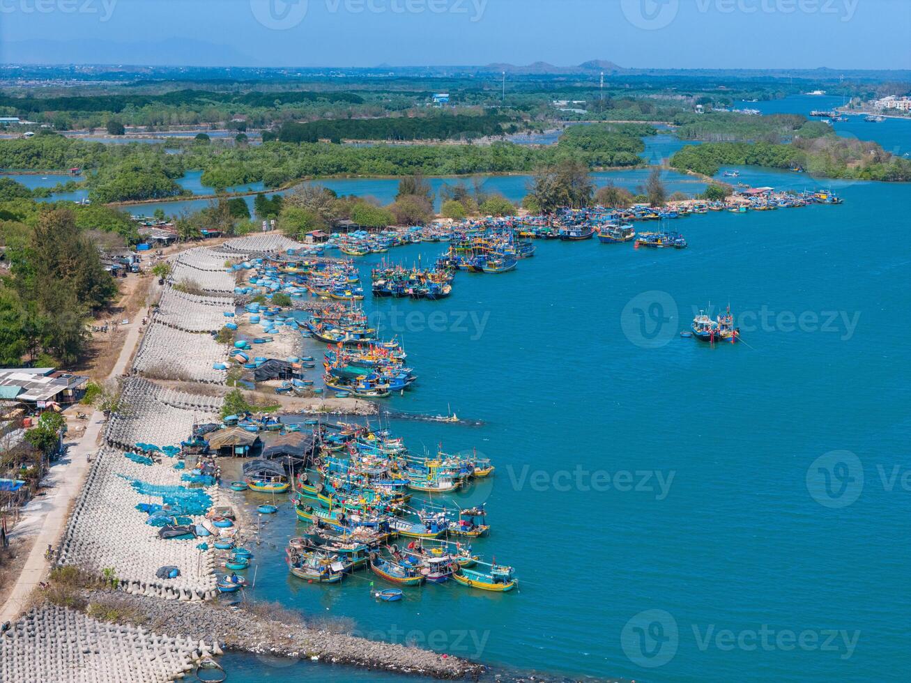 aérien vue de loc un pêche village, vung tau ville. une pêche Port avec tsunami protection béton blocs. paysage urbain et traditionnel bateaux dans le mer. photo