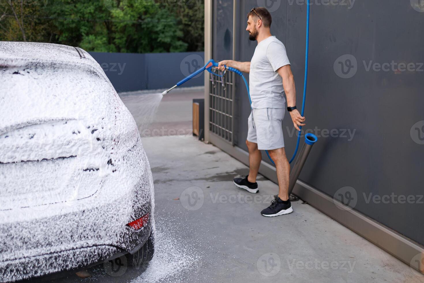 partie de le voiture est couvert avec mousse, le la personne dans le Contexte est appliquant mousse à le auto. une voiture à une soi un service voiture laver. photo