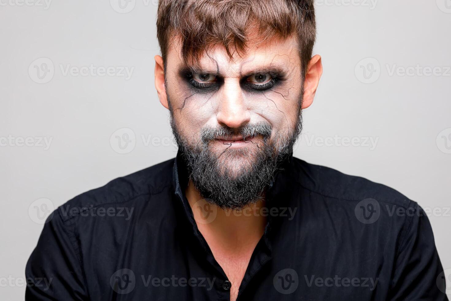 portrait de une homme avec une barbe et une menaçant Regardez avec style mort-vivant maquillage sur tout des saints journée sur octobre 31 photo