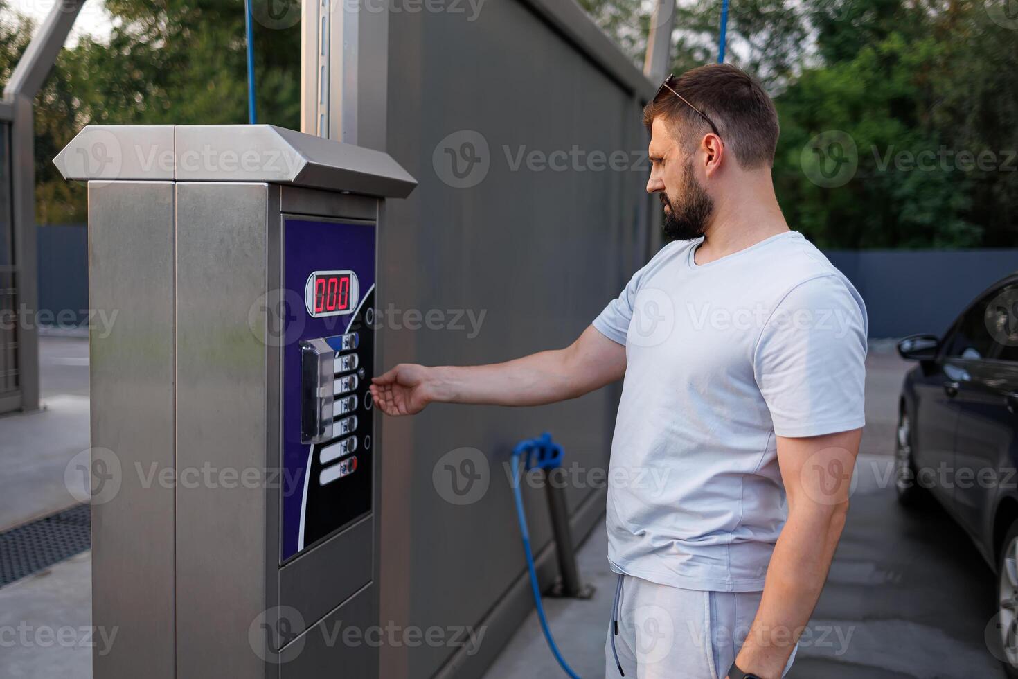 après paiement, le homme sélectionne le voiture laver mode. une voiture à une soi un service voiture laver. photo