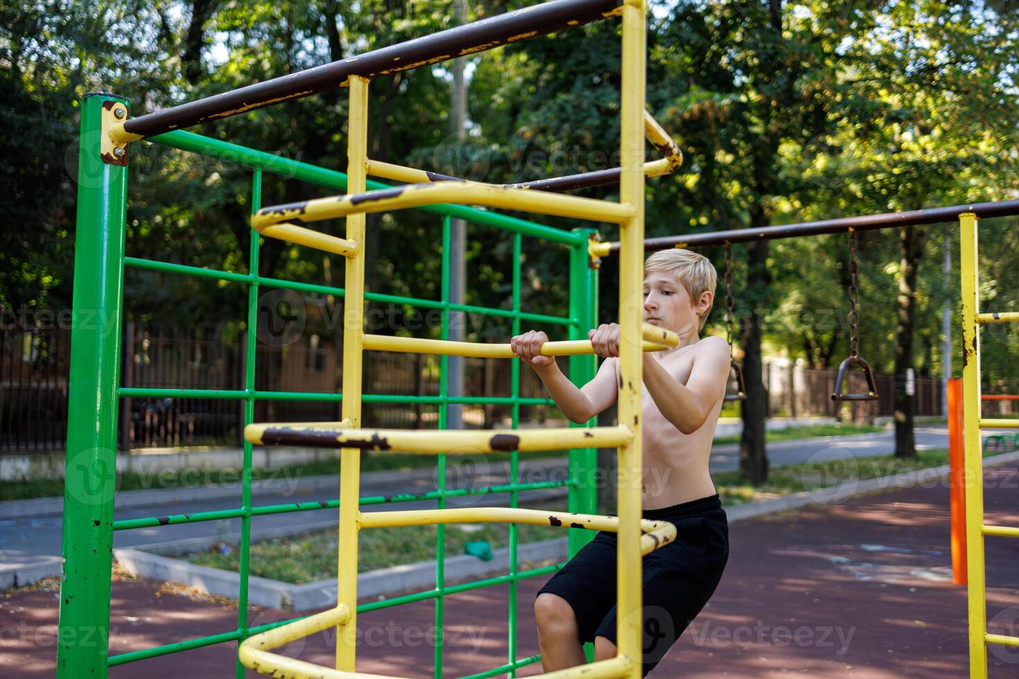 des sports adolescent sur le gymnastique escaliers dans le parc. rue faire des exercices sur une horizontal bar dans le école parc. photo