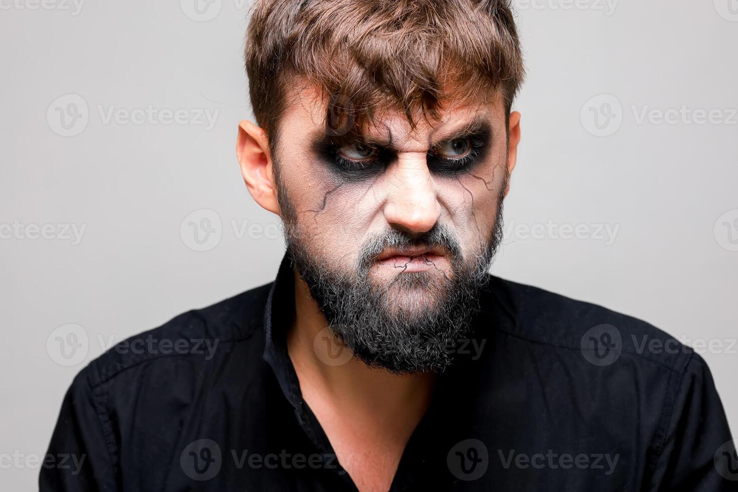 portrait de une homme avec une barbe et une menaçant Regardez avec style mort-vivant maquillage sur tout des saints journée sur octobre 31 photo