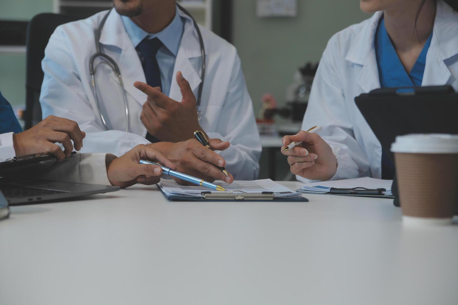 équipe de médical Personnel ayant Matin réunion dans salle de réunion. médecins et infirmières à la recherche à numérique tablette. photo