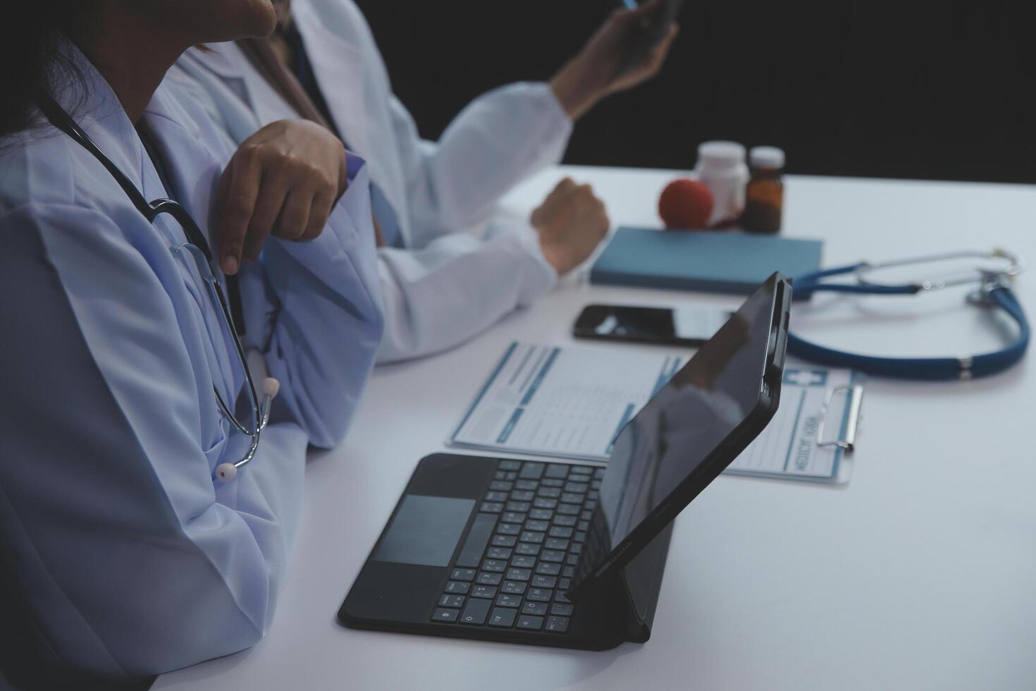 médecin discuter diagnostic pendant le réunion. groupe de médecin discuter travail matière dans le Bureau à travail. le médical équipe discute traitement les options avec le patient. photo