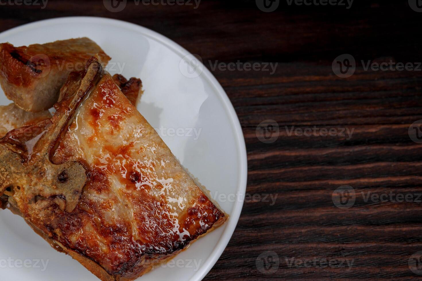 rôti porc entrecôte Couper dans pièces dans une blanc assiette sur une en bois Coupe planche . grillé porc entrecôte. porc steak. photo