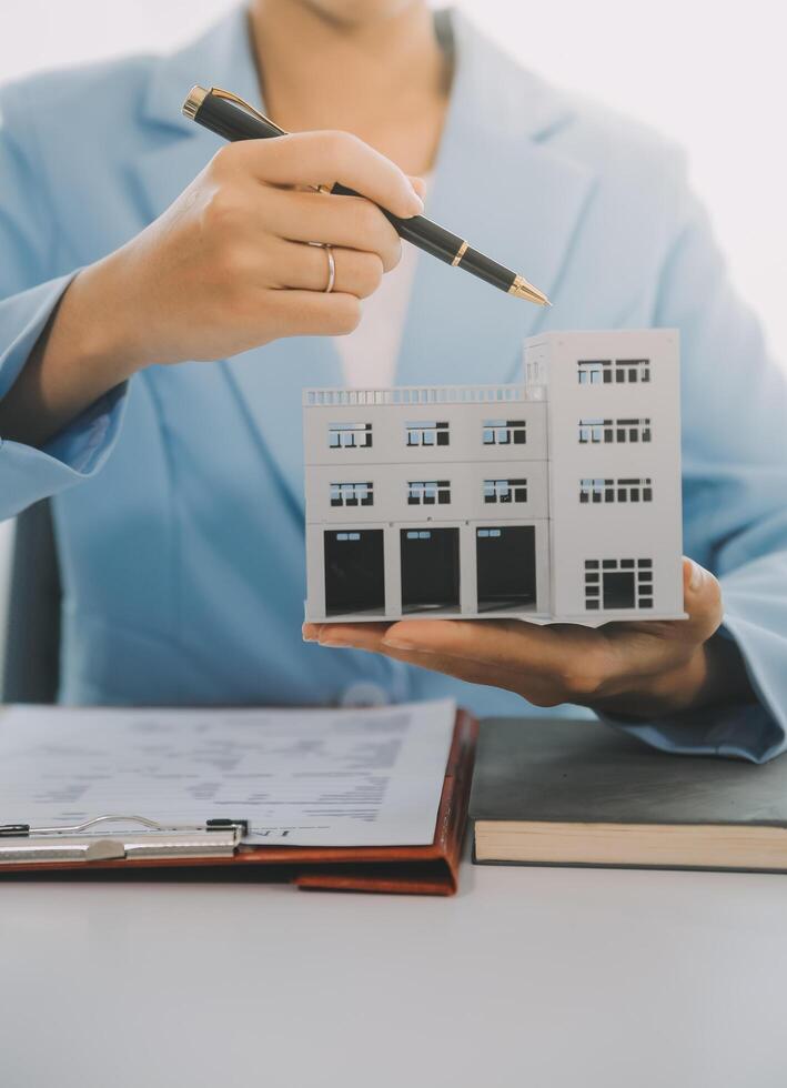 L'agent immobilier a parlé des termes du contrat d'achat de maison et a demandé au client de signer les documents pour conclure le contrat légalement, les ventes de maisons et le concept d'assurance habitation. photo