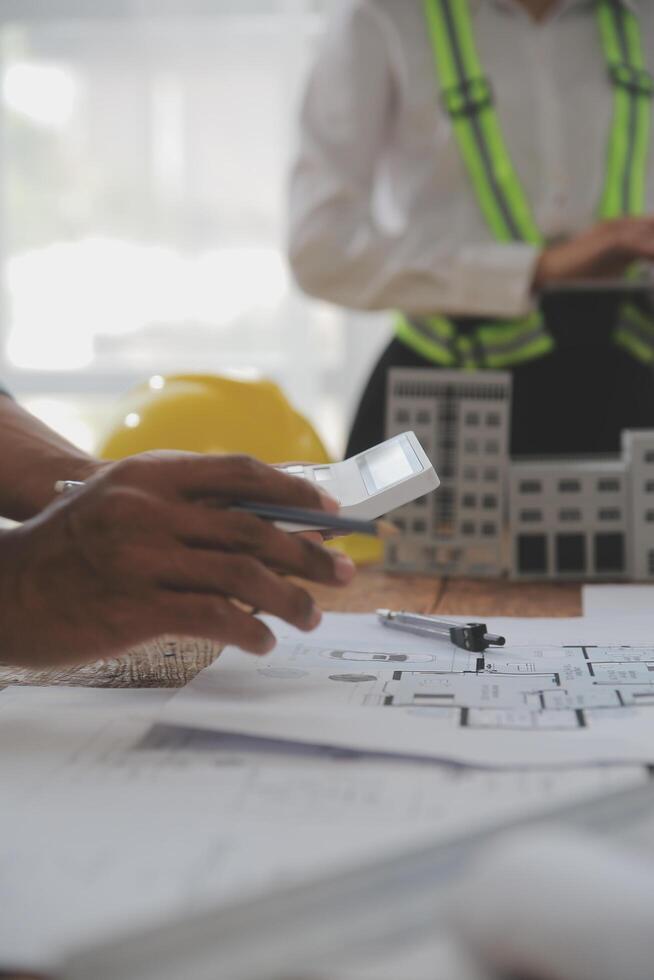 concept de construction et de structure d'une réunion d'ingénieur ou d'architecte pour un projet de travail avec des partenaires et des outils d'ingénierie sur la construction de modèles et le plan sur le chantier, contrat pour les deux sociétés. photo