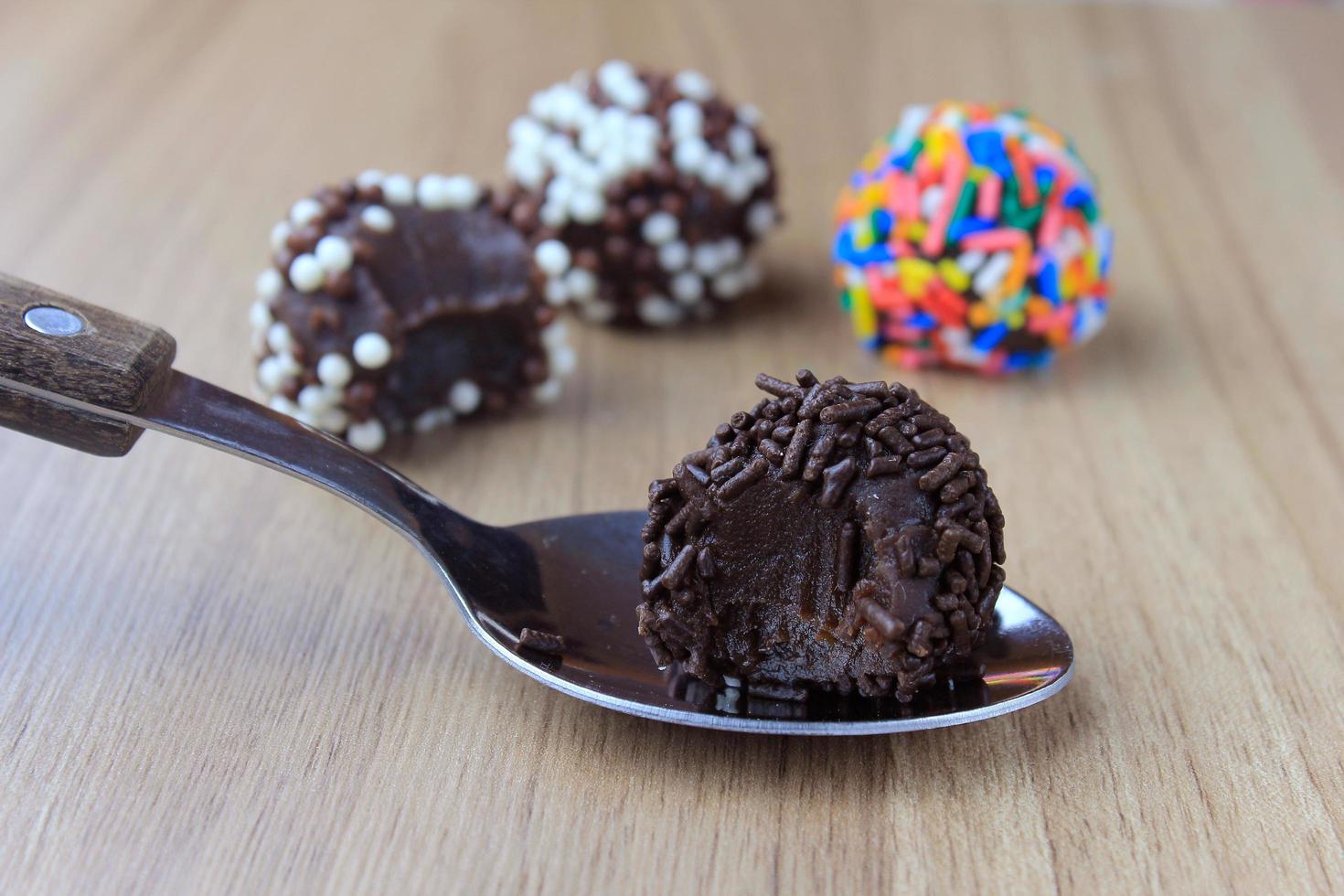 brigadeiro, brigadier, chocolat sucré typique de la cuisine brésilienne recouvert de particules, dans un fond en bois. photo