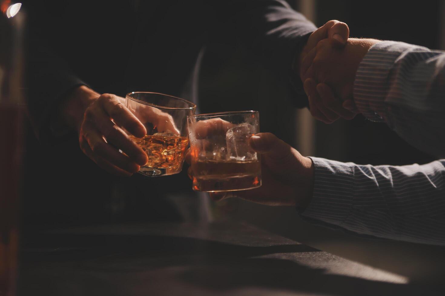 fête nuit, verser whisky dans une verre. donner à copains qui viens à célébrer photo