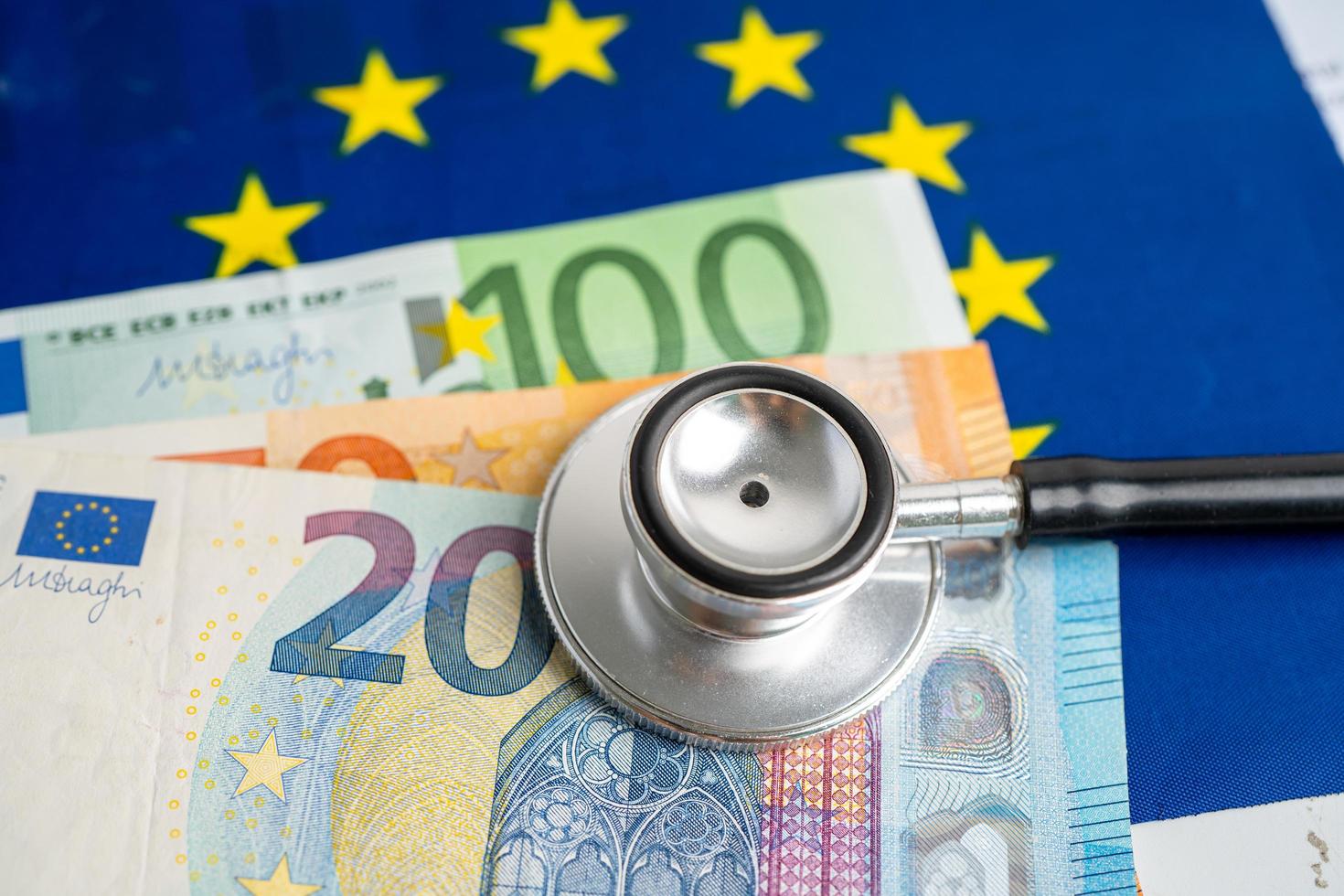 stéthoscope noir sur le drapeau de l'ue en europe avec des billets de banque concept d'argent, d'affaires et de finance. photo