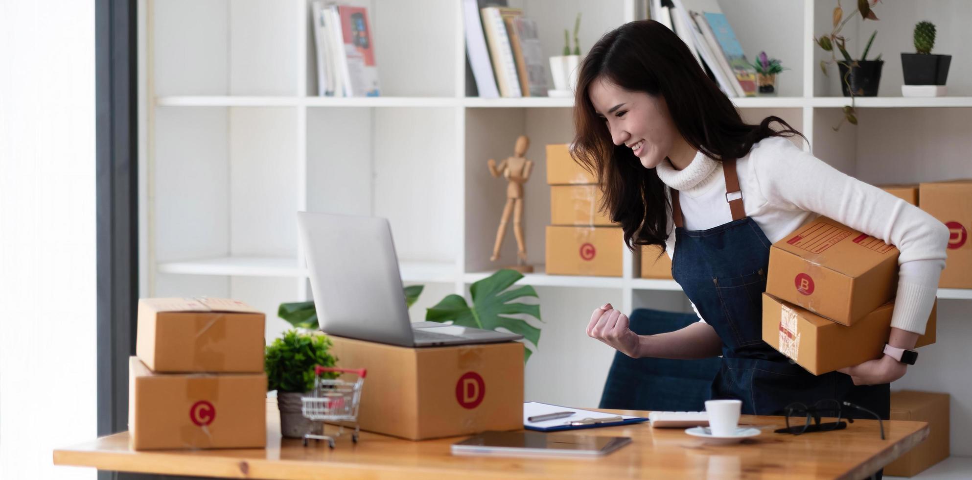 succès d'une jeune femme asiatique pour les affaires en ligne, jeune femme propriétaire qui démarre une entreprise en ligne. personnes ayant des achats en ligne, un entrepreneur en PME ou un concept de travail indépendant. photo