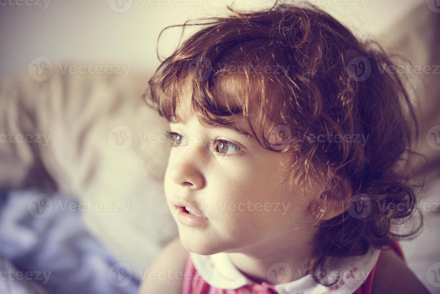 adorable petite fille aux cheveux bouclés ébouriffés photo