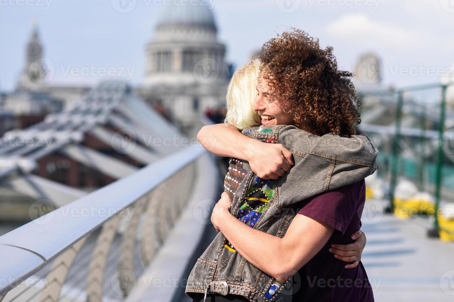 couple heureux étreignant par millenium bridge, tamise, londres. photo