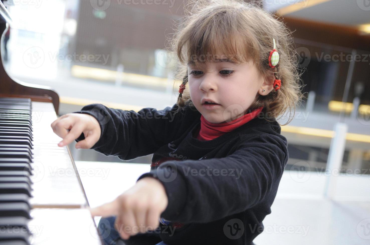 petite fille s'amusant à jouer du piano photo