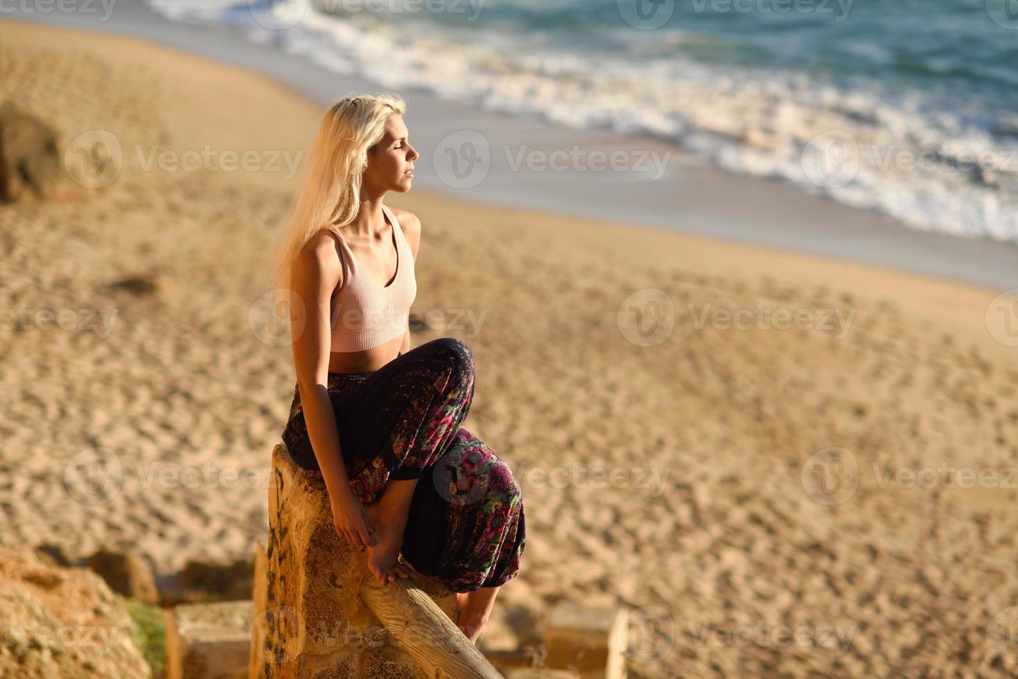 femme profitant du coucher de soleil sur une belle plage photo