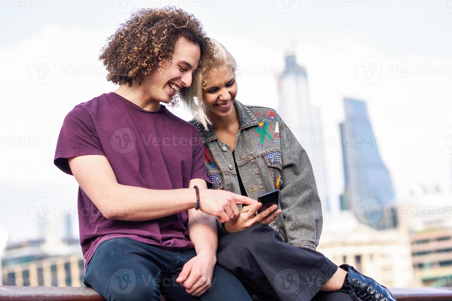 couple heureux parlant assis près de la tamise. photo