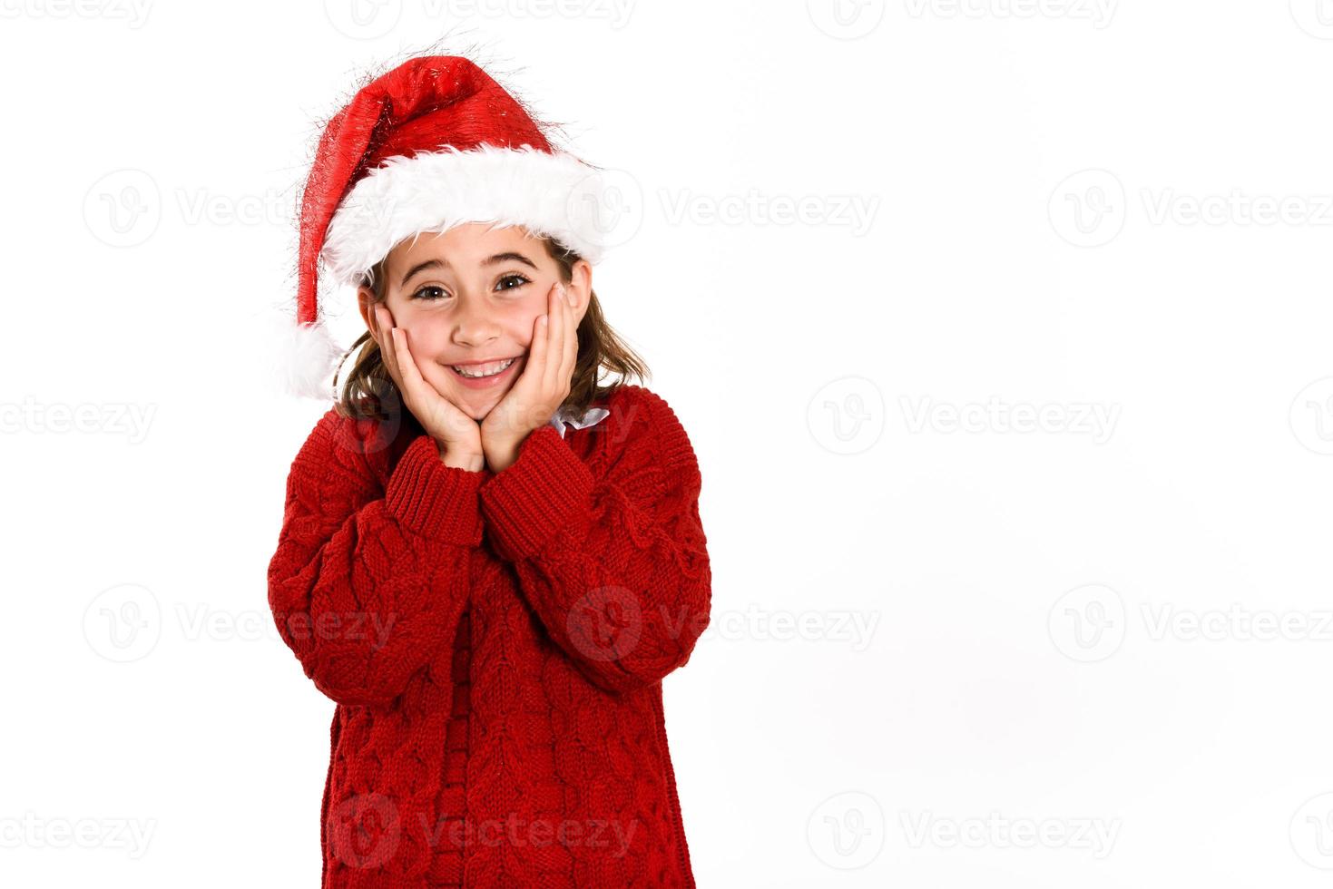 Adorable petite fille portant un bonnet de noel isolé sur fond blanc photo