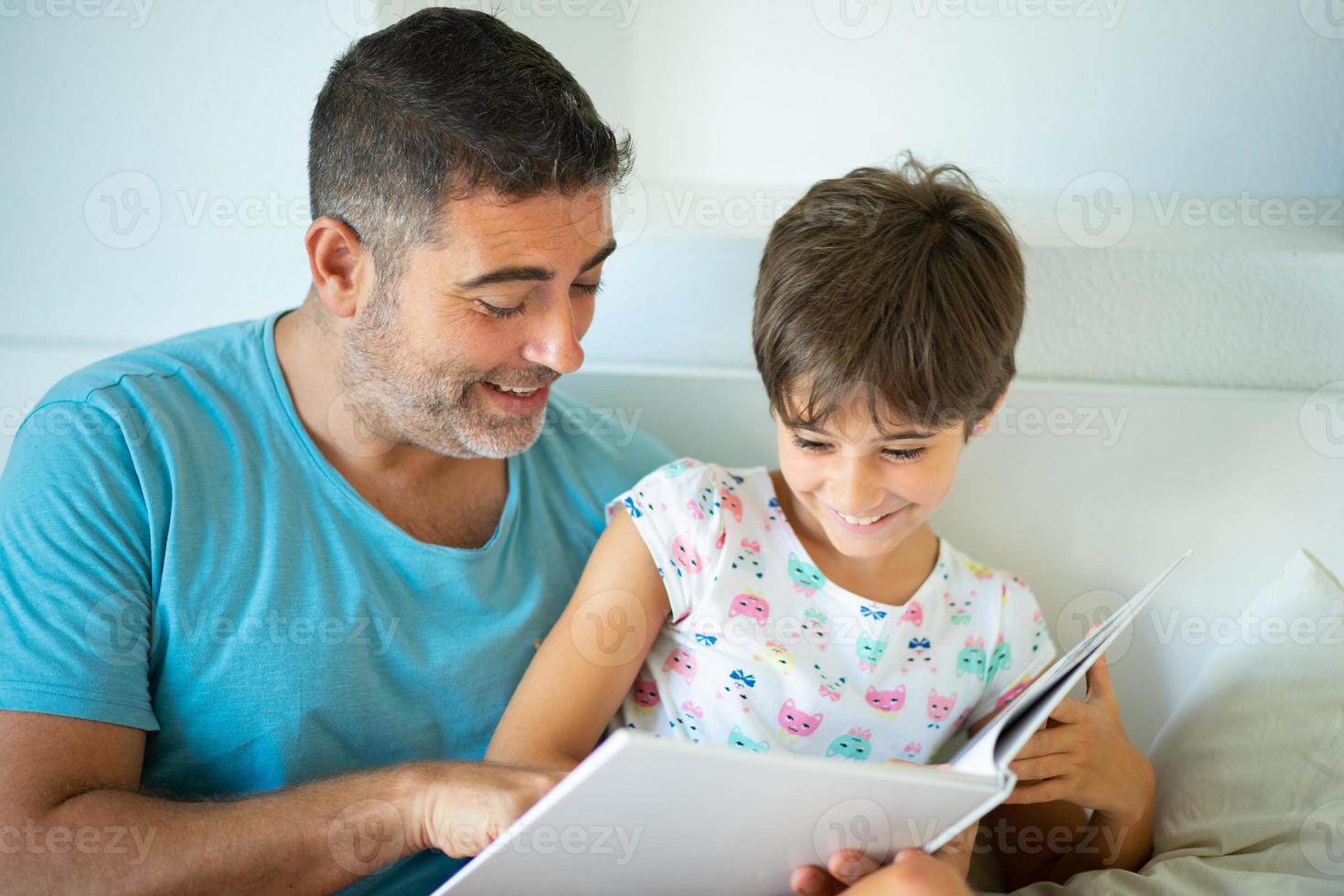 père d'âge moyen avec sa fille de huit ans utilisant une tablette numérique dans la chambre. photo