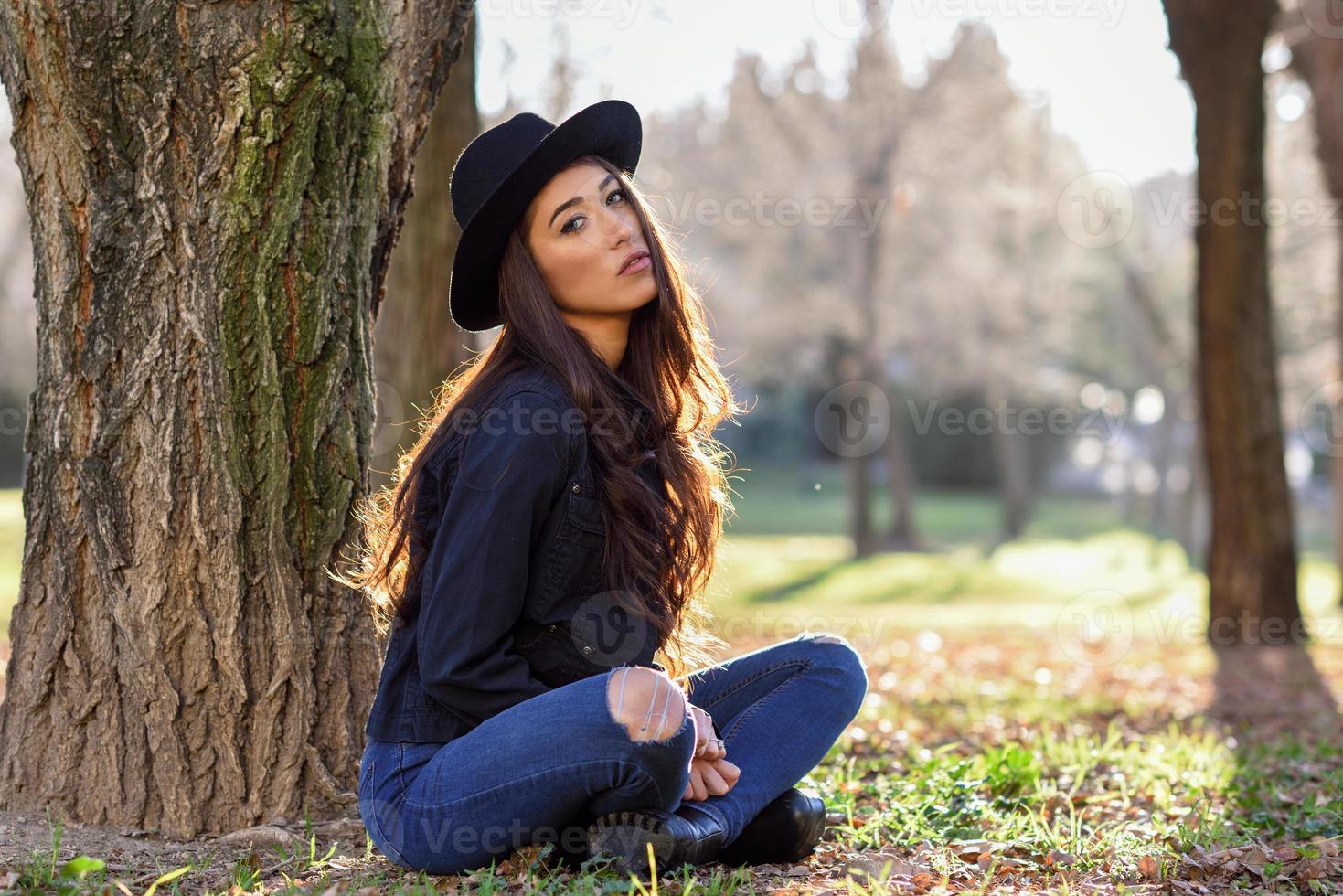 femme réfléchie assise seule à l'extérieur portant un chapeau photo