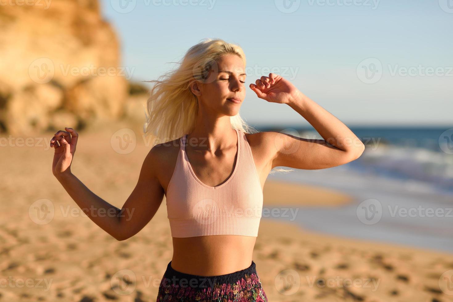 femme profitant du coucher de soleil sur une belle plage photo