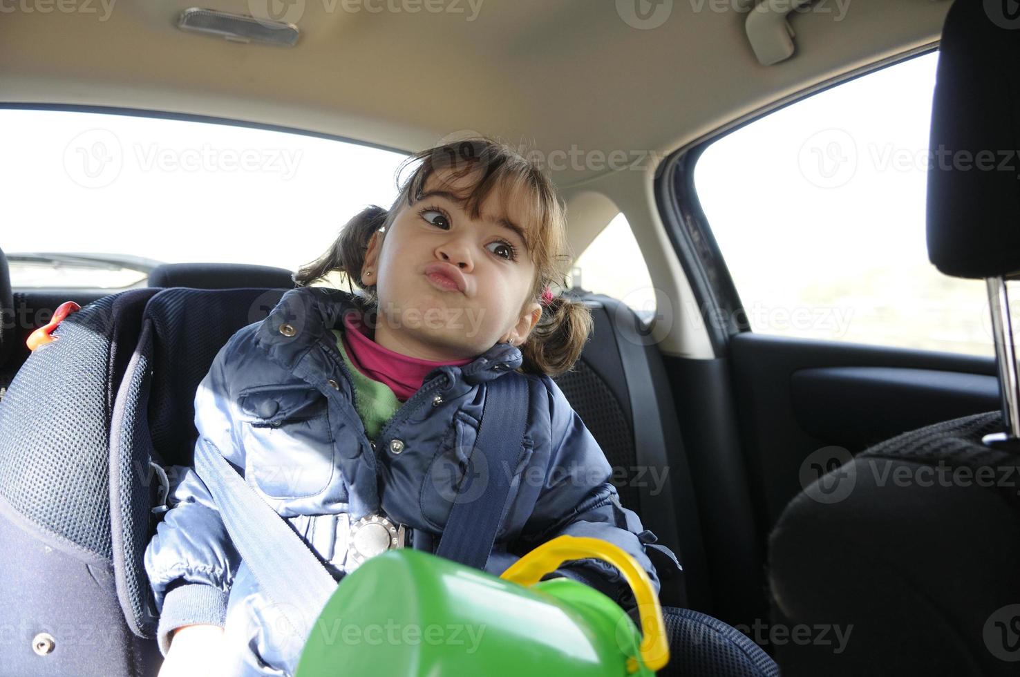 petite fille voyageant en voiture assise dans son siège de sécurité photo