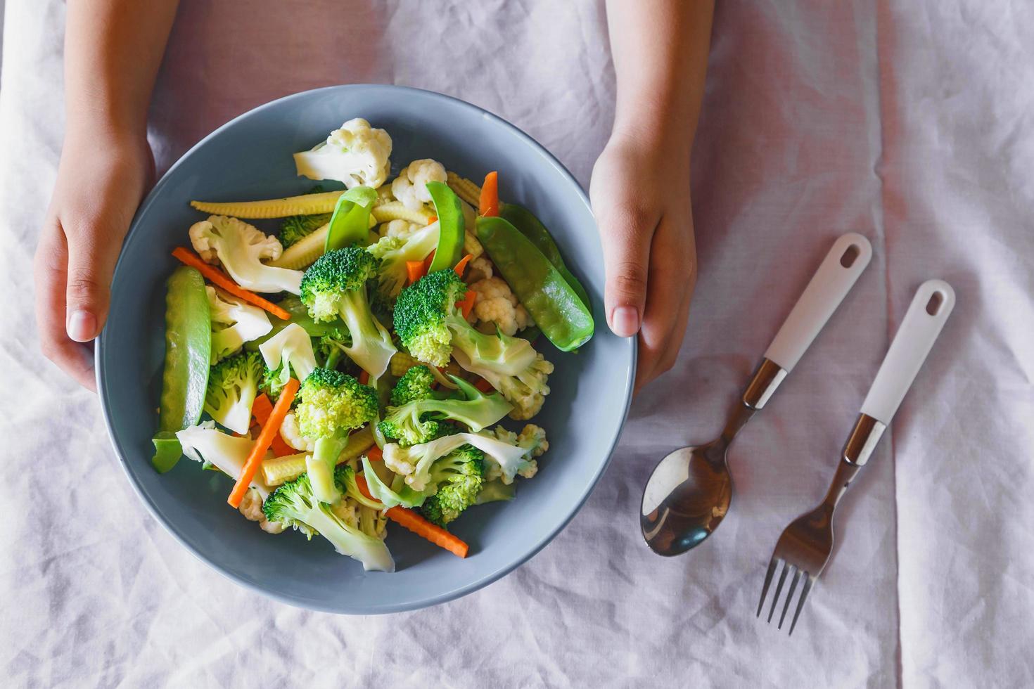 nourriture végétale mélangée sur le bol dans la main, légumes mélangés sains. photo