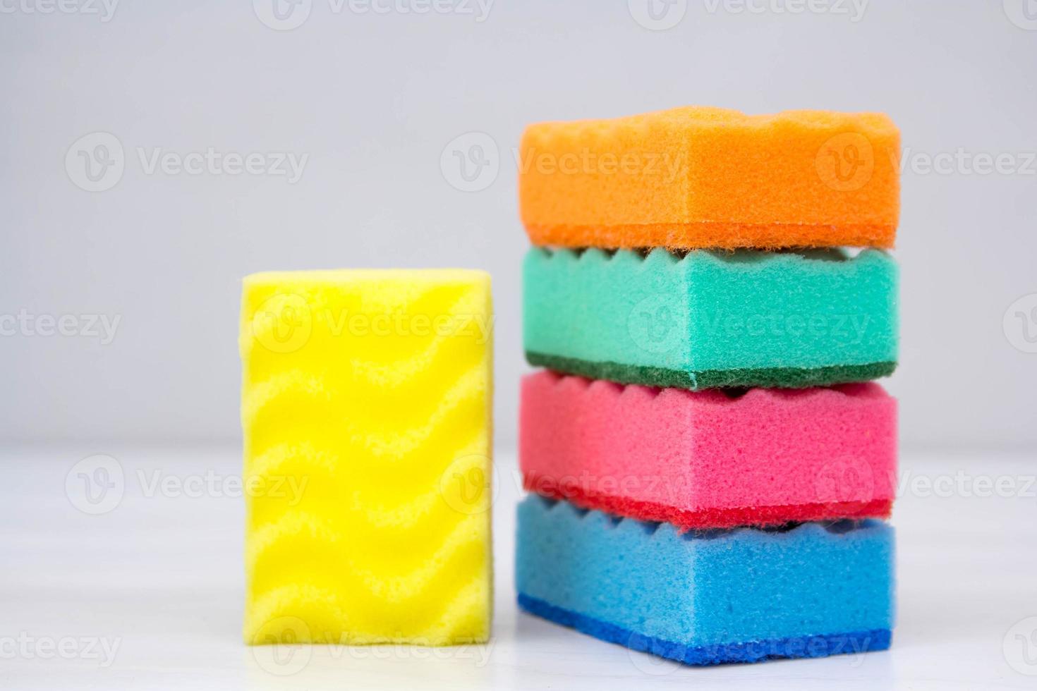 éponges multicolores pour nettoyer et laver la vaisselle sur une table blanche photo