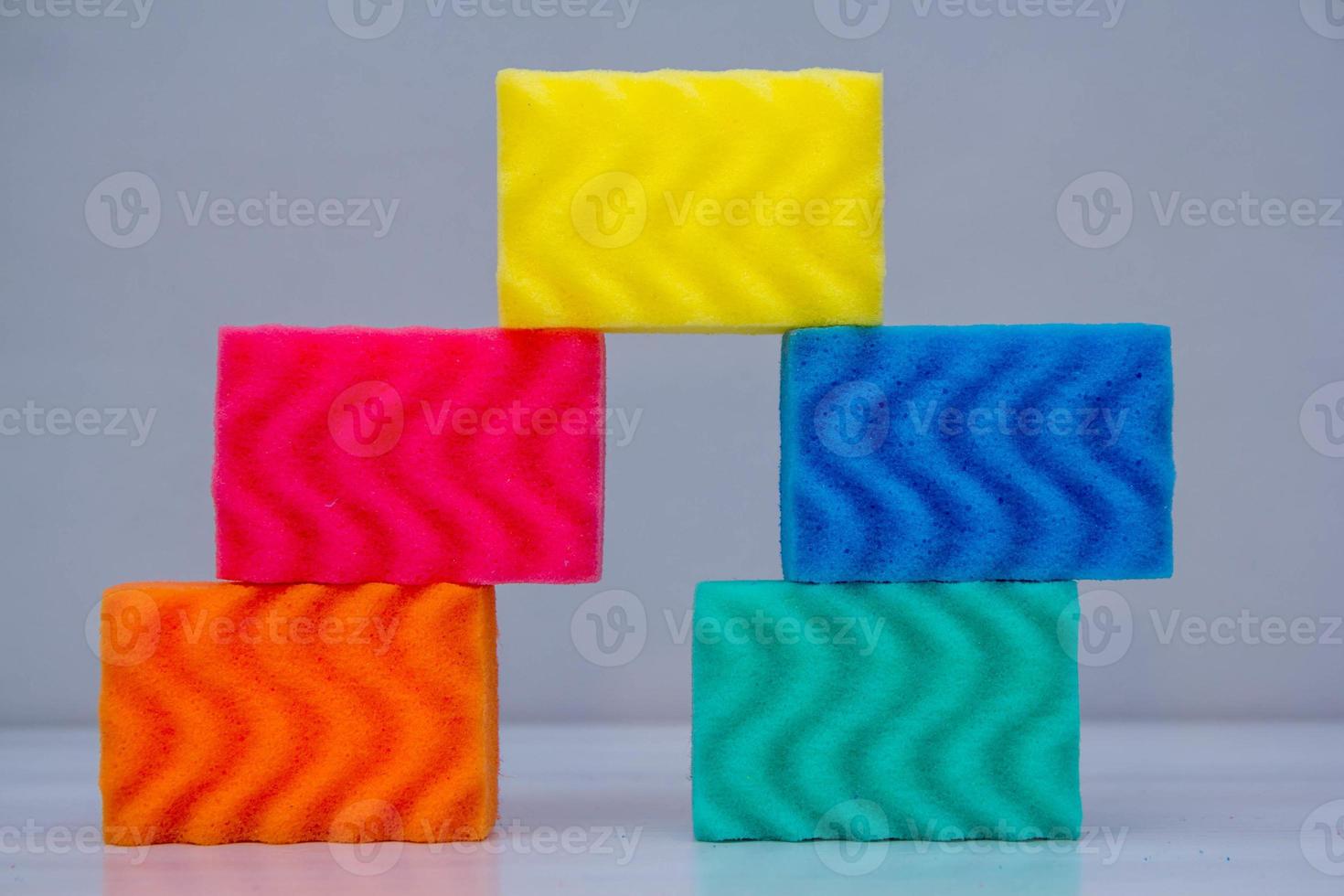 éponges multicolores pour nettoyer et laver la vaisselle sur une table blanche photo