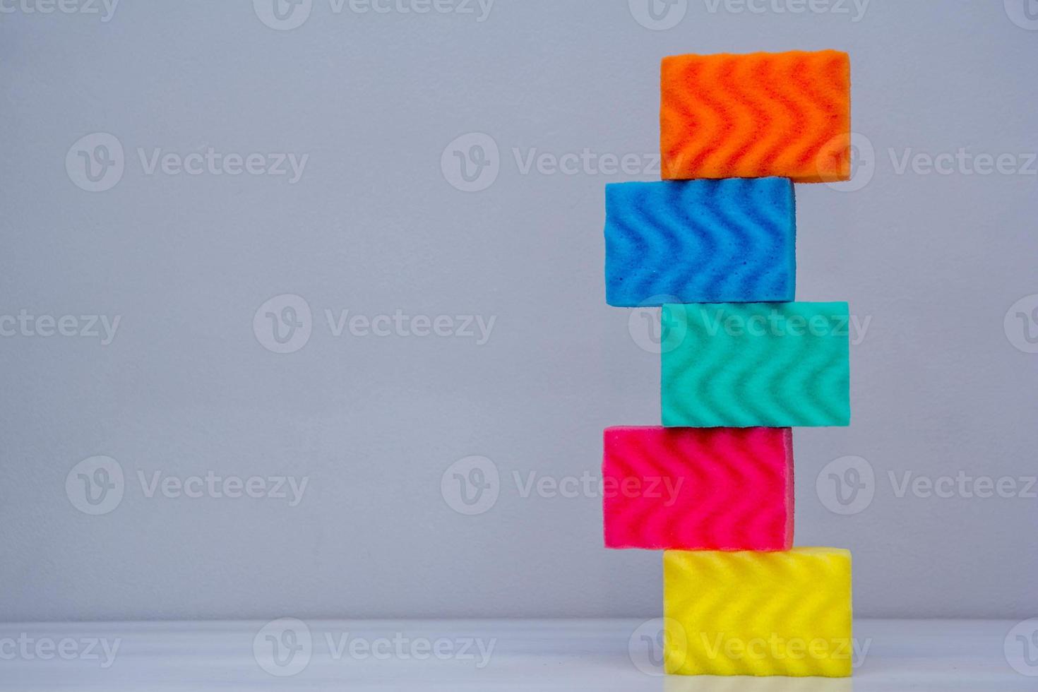 éponges multicolores pour le nettoyage sur une table blanche photo