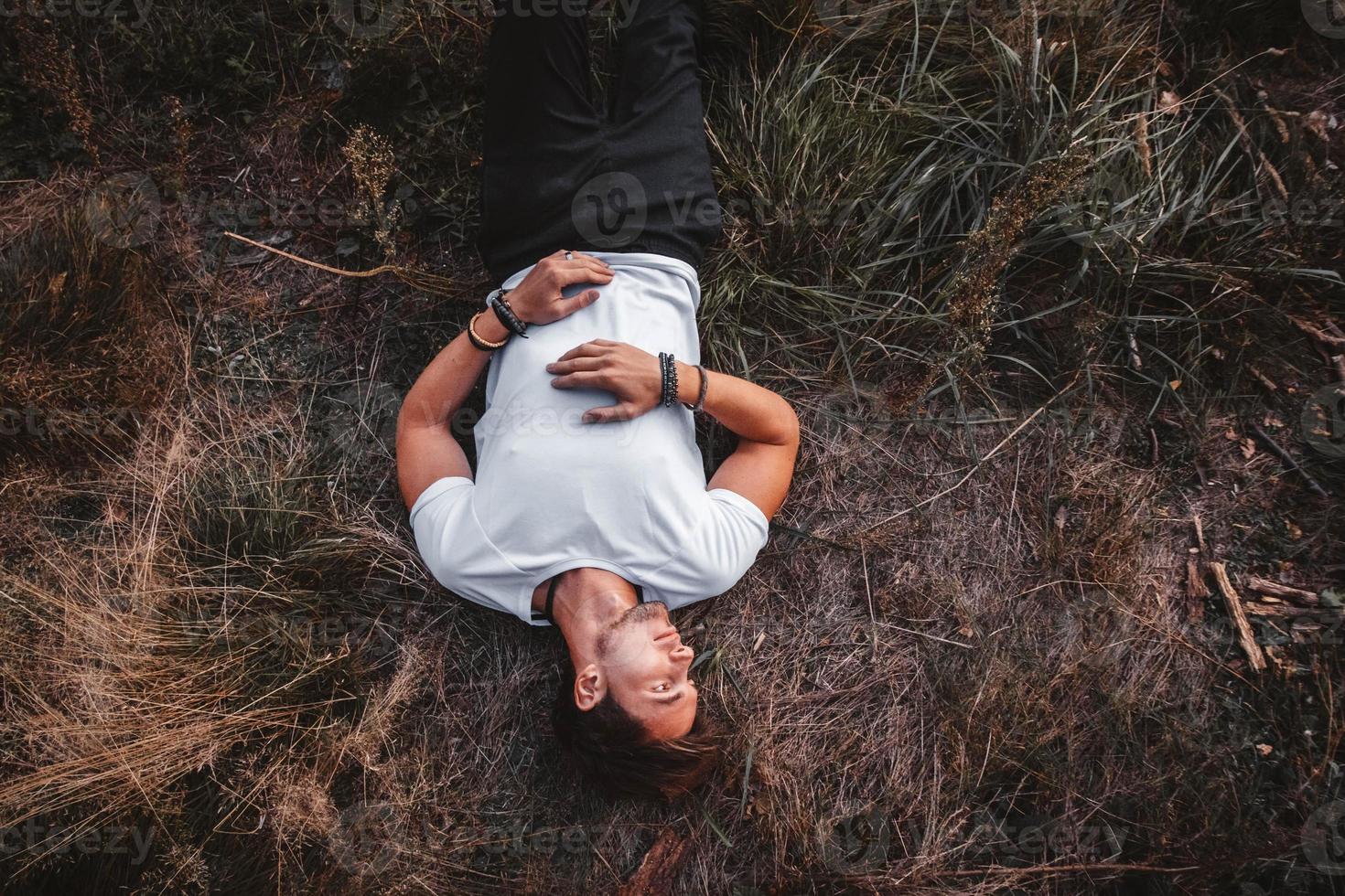 l'homme se trouve sur l'herbe au milieu de la forêt relaxante photo