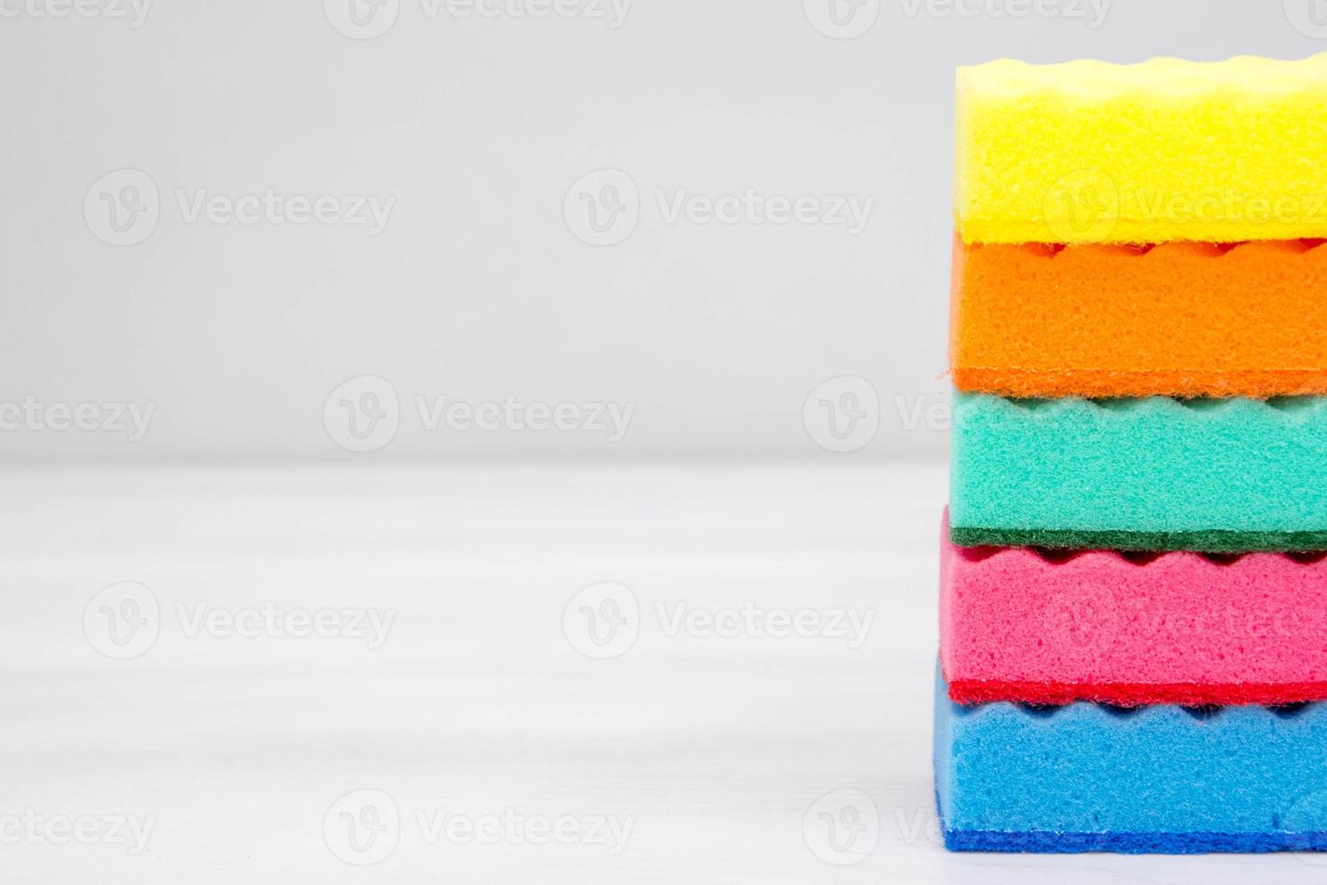 éponges multicolores pour le nettoyage sur une table blanche photo