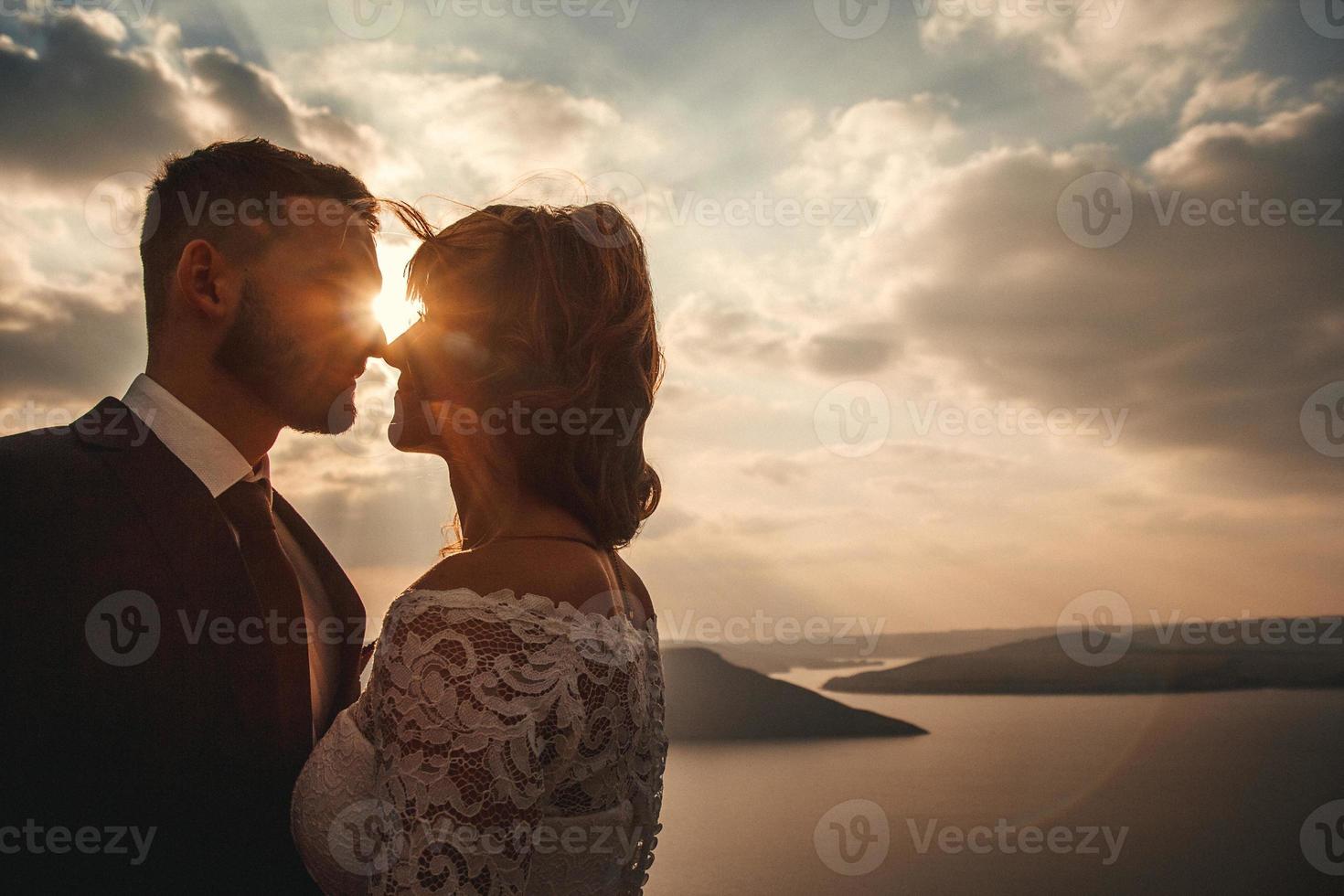 couple de mariage, la mariée et le marié se tenant la main sur un fond de montagnes et de rivières photo