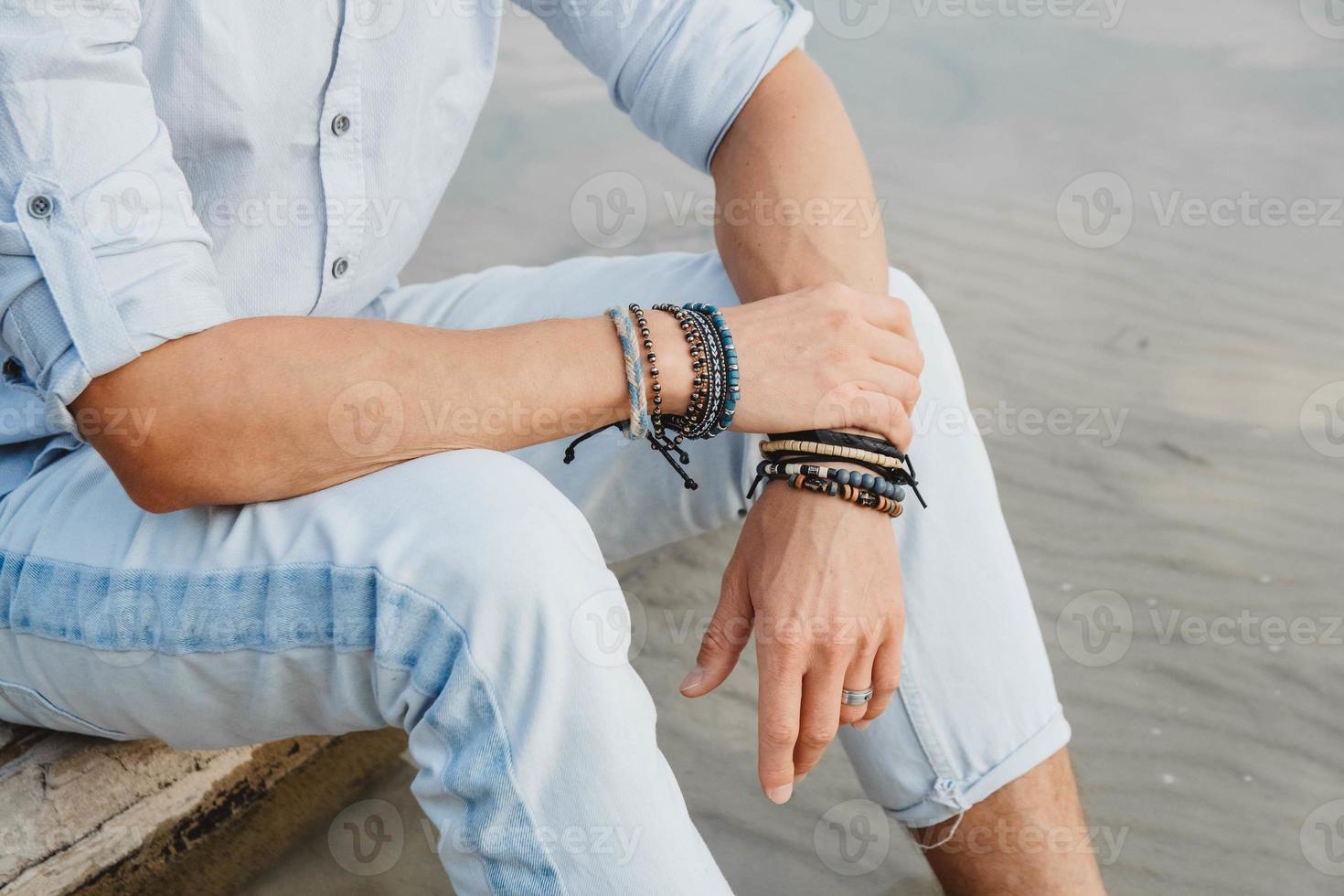 mains d'homme avec des bracelets sur les deux mains photo