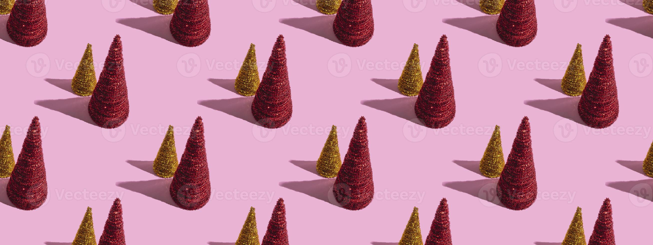 arbres de noël colorés sur fond rose. concept de noël, modèle sans couture photo