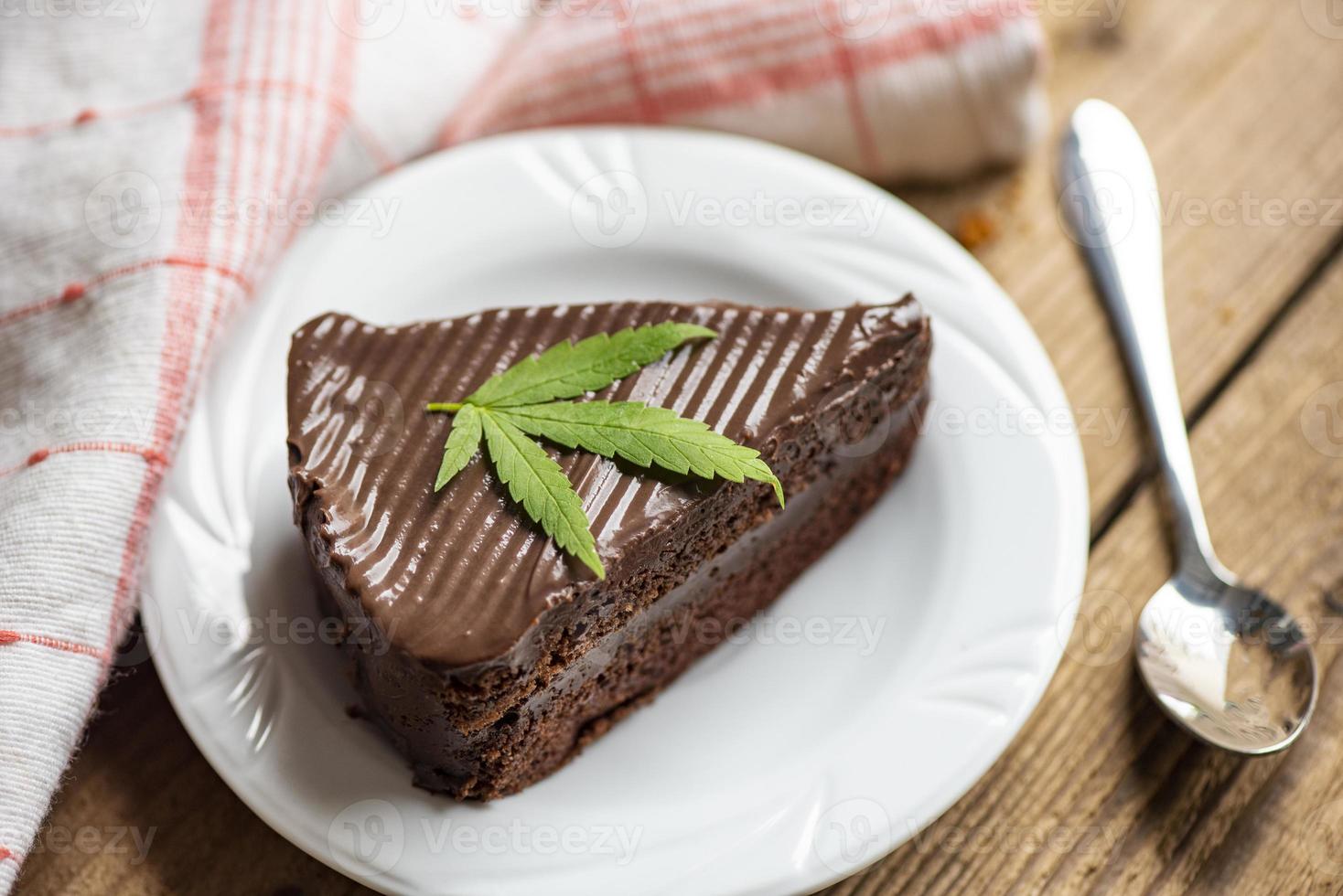 gâteau au chocolat avec feuille de cannabis - plante de feuilles de marijuana sur une plaque blanche sur la table en bois, concept d'herbe nature nourriture cannabis photo