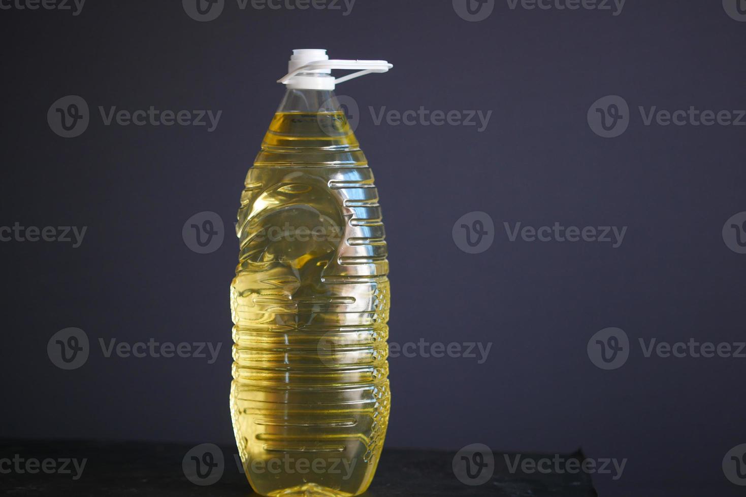 Bouteille d'huile de tournesol sur table sur fond gris photo