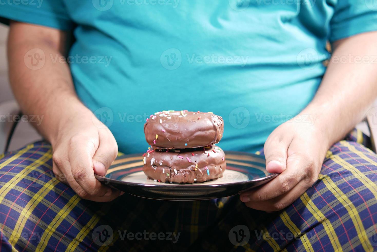 jeune homme mangeant des beignets, mise au point sélective photo