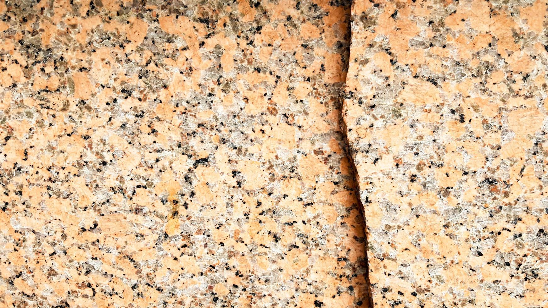 véritable motif de granit brun naturel, tranche minérale polie. texture béton endommagée en marbre fissuré sans couture. arrière-plan architectural. taches brunes sur fond de pierre. marbrure photo