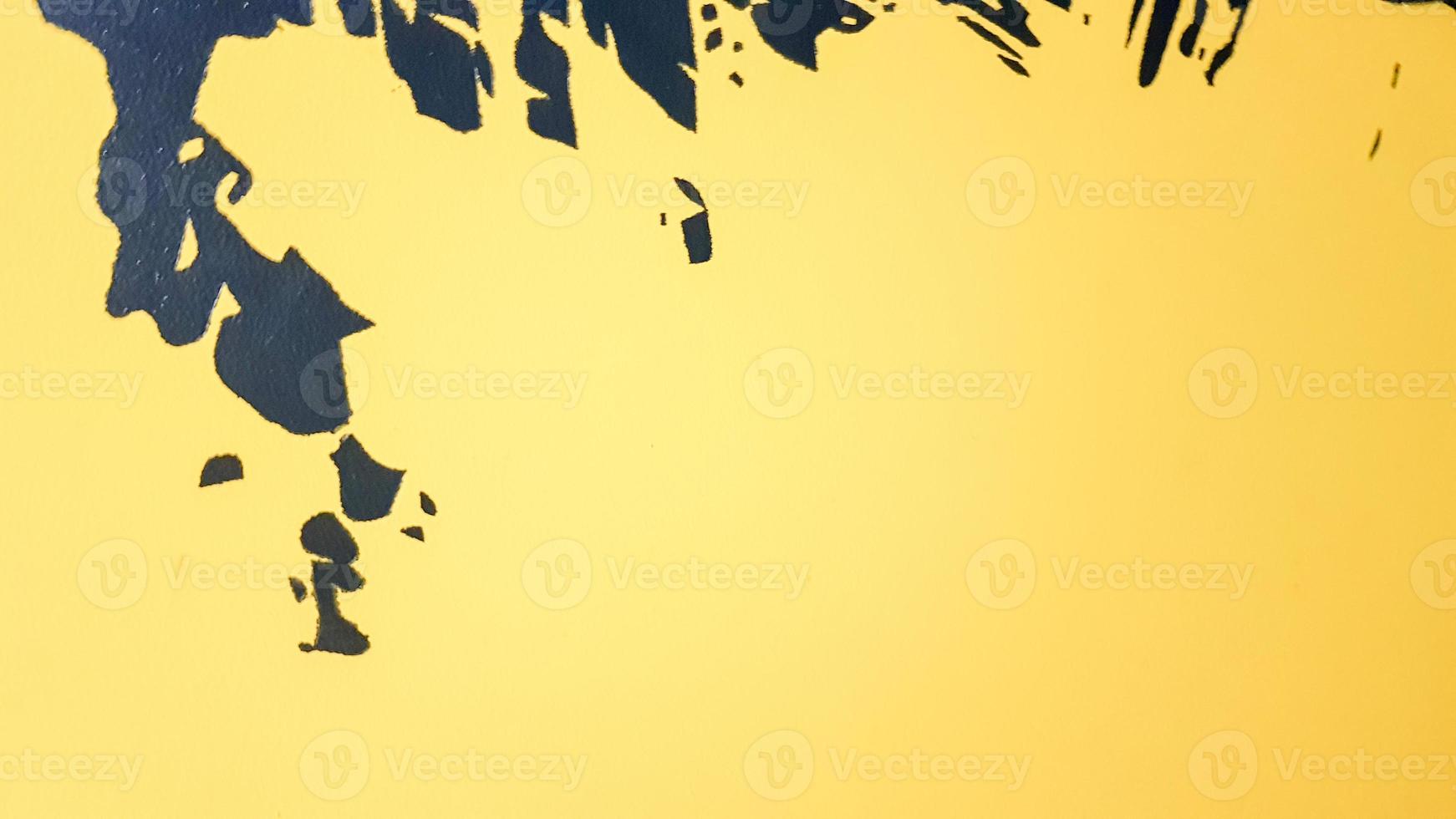 éclaboussures de peinture abstraite noire dégoulinant sur un fond jaune vif. éclaboussures de peinture noire sur fond jaune. concept d'idées artistiques. pinceau texture jaune et noir sur fond photo