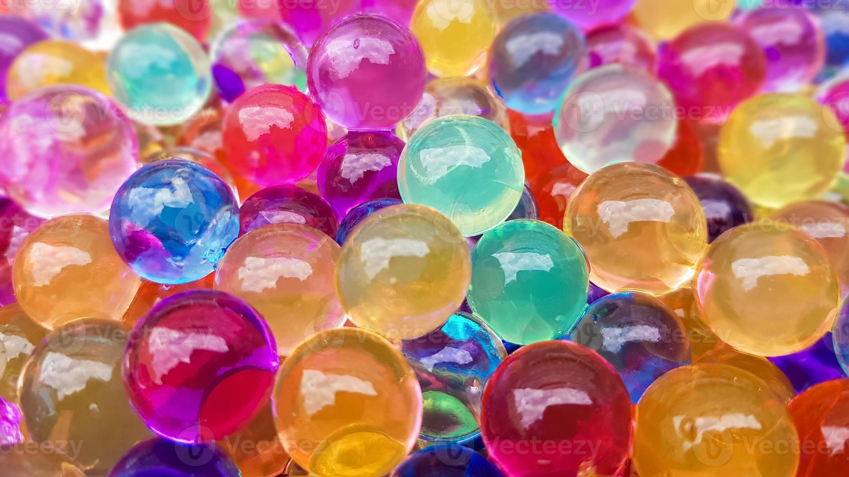 beaucoup de boules d'hydrogel de couleurs différentes. ensemble d'orbis multicolores. perles d'eau en cristal pour les jeux. ballons à l'hélium. peut être utilisé comme arrière-plan. gel polymère gel de silice. photo