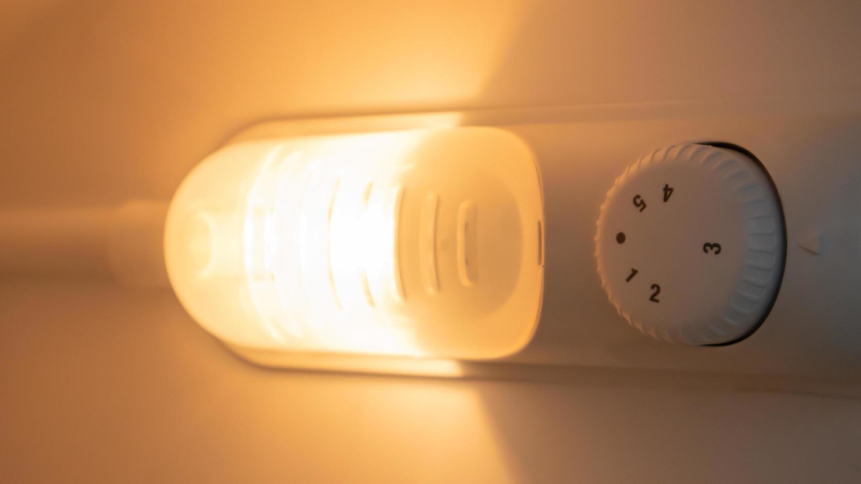 lumière orange à l'intérieur du gros plan du réfrigérateur. une lampe qui s'allume lorsque la porte est ouverte pour améliorer la vision. concept d'électroménager, changement de lampe dans le congélateur. photo