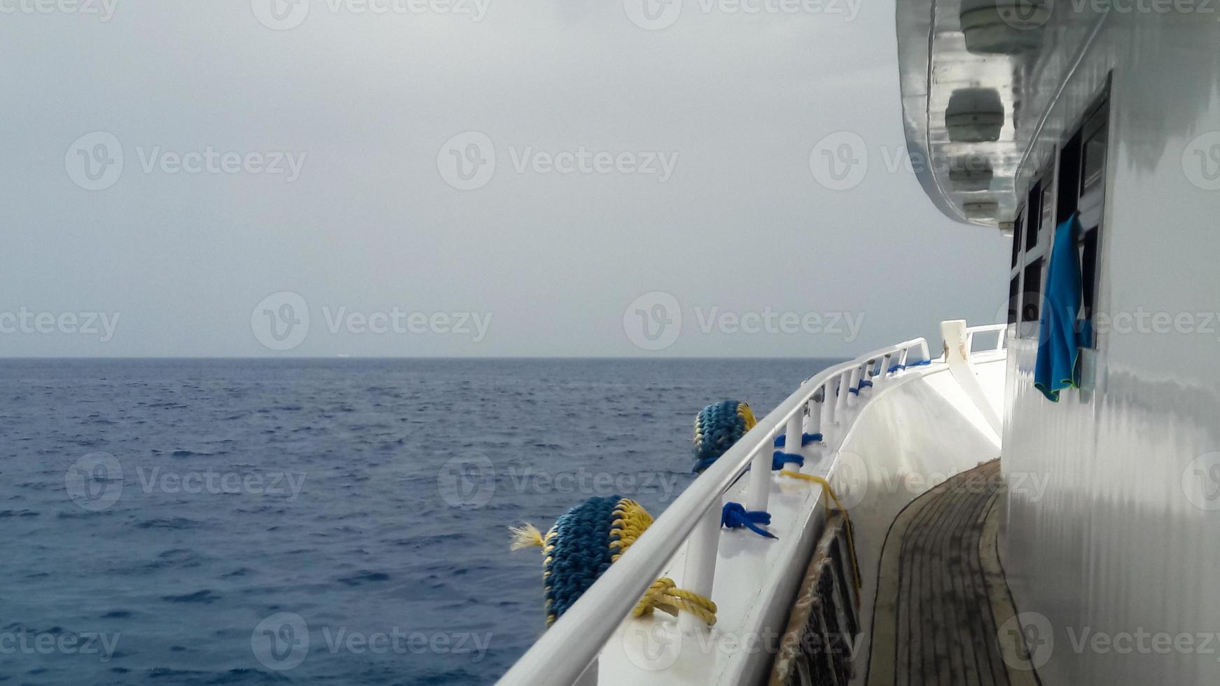 belle vue depuis le pont d'un bateau de croisière sur la mer rouge en égypte. paysage de la côte rocheuse égyptienne avec un yacht. partie du navire sur fond de désert et de mer. photo