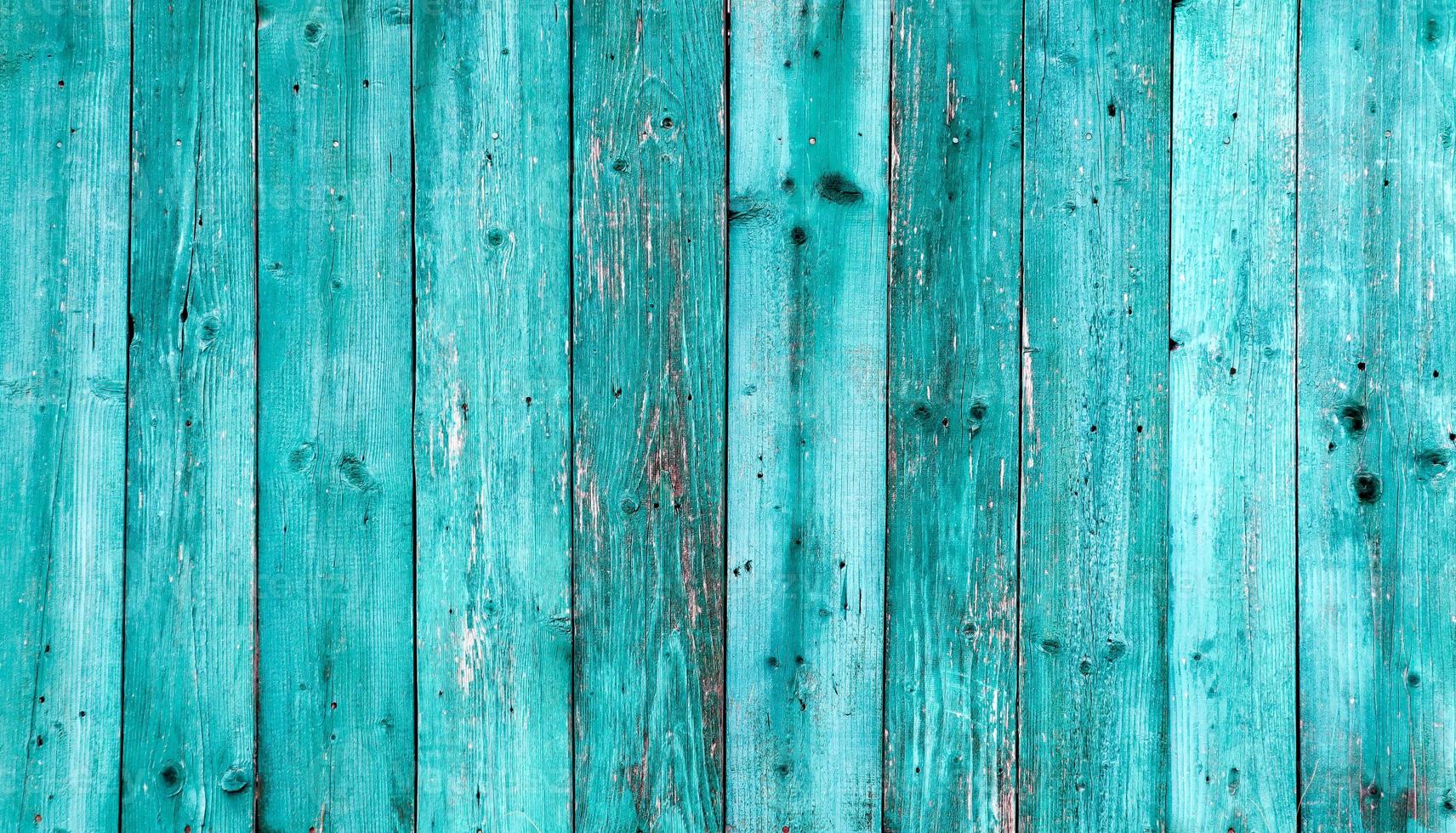 vieux fond de texture bois bleu foncé. mur en bois peint. fond bleu une clôture lumineuse faite de planches verticales. la texture d'une planche de bois peut être utilisée pour l'arrière-plan. un peu de peinture craquelée. photo