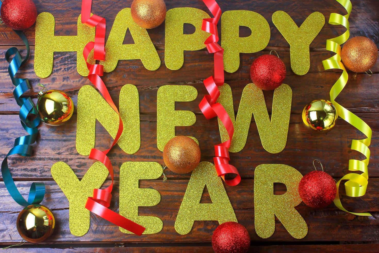 affiche de célébration de bonne année, message de bienvenue avec des ornements sur fond en bois photo