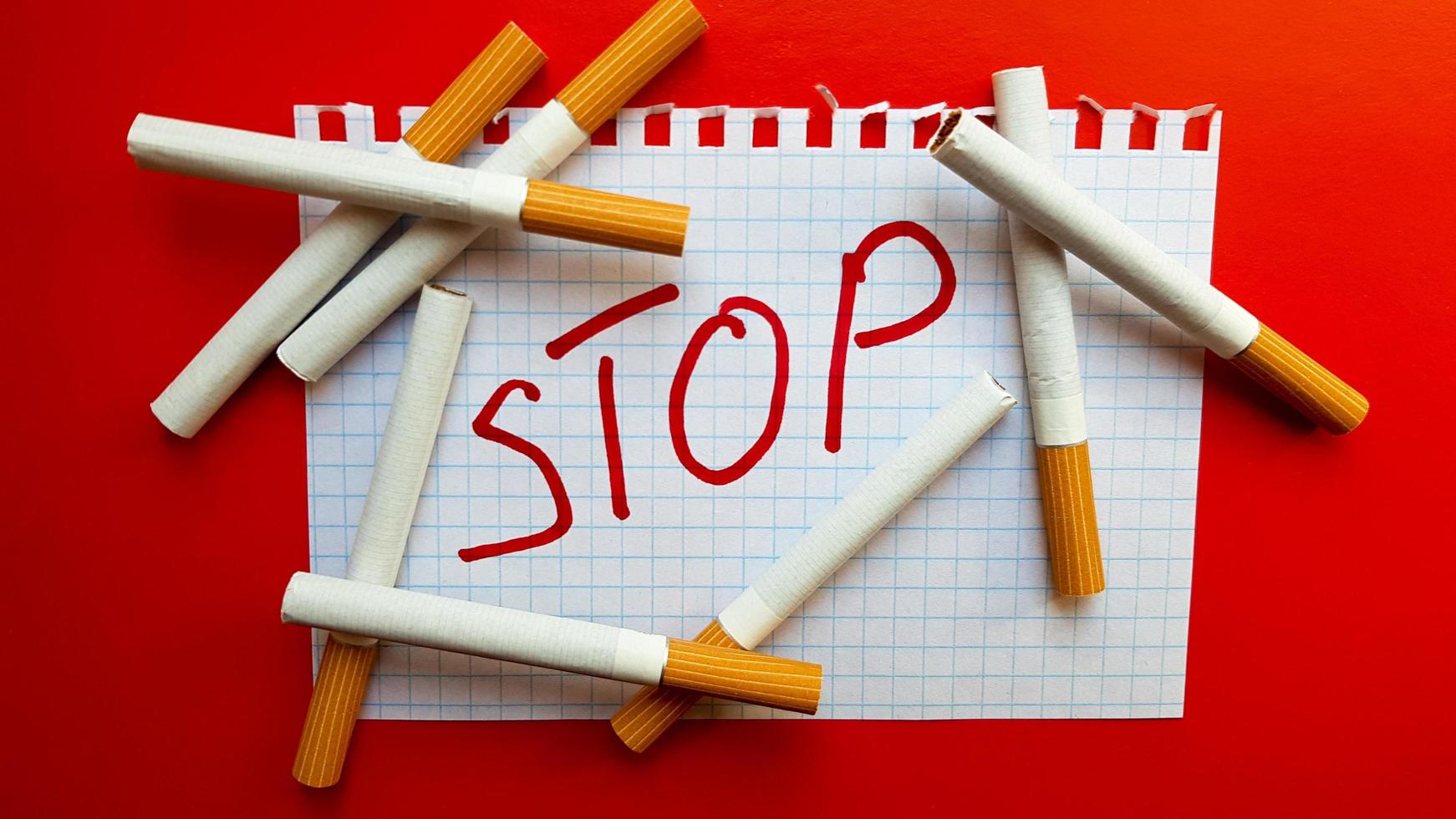 un autocollant qui dit stop est dans un paquet de cigarettes. journée mondiale sans tabac. arrêter de fumer. se battre avec des cigarettes photo