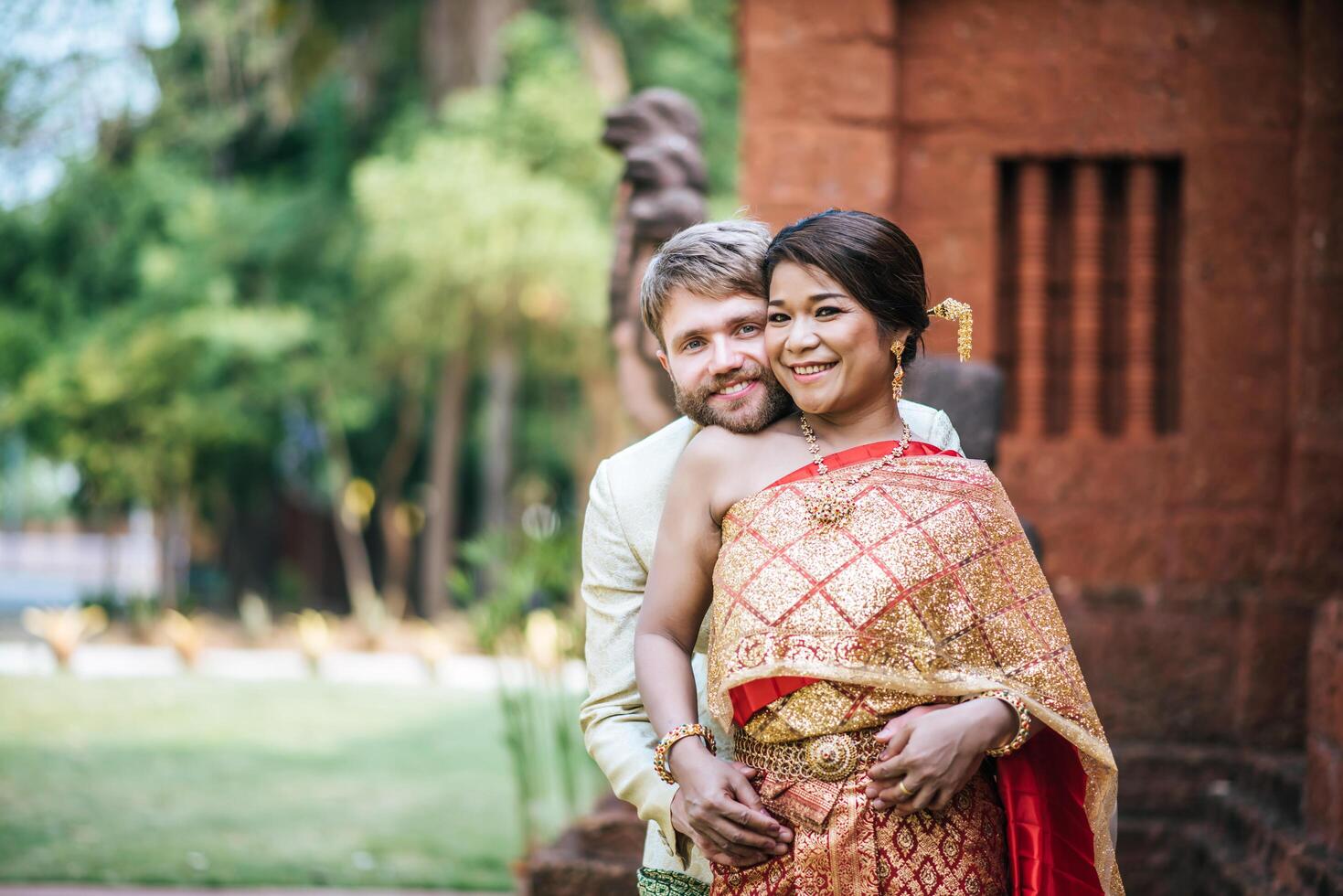 la mariée asiatique et le marié caucasien passent un moment romantique avec une robe thaïlandaise photo